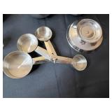 Collection of Stainless Steel Mixing Bowls and Measuring Cups with Decorative Globe and Salt Shakers