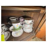 BOTTOM SHELF OF TEA CUPS IN BOTTOM OF CABINET IN D