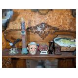 DECOR AND CURIOSITIES ON UPPER SHELF MARKED 1351 INCLUDING HAND CARVED MODERN MAN TOTEM, EAGLE FIGURINE, HEAD MUG, BIG MOUTH BILLY BASS, OLD CAMERA MOTIF PENCIL SHARPENER, AND MORE