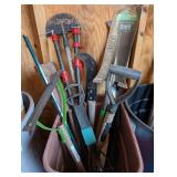 LARGE GARBAGE CAN FILLED WITH GARDEN TOOLS, SCYTHE, PIPE CLAMPS, AND MORE