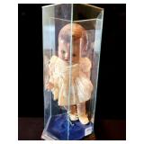 COMPOSITION BABY DOLL IN GLASS DISPLAY CASE -