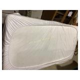 mattress with a protective white cover,