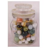 Vintage swirl glass marbles in glass canister,