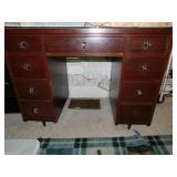 Small dark wooden desk w/ seven drawers, missing