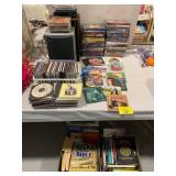 LARGE GROUP OF CDS, SPEAKERS, BOOKS UNDER TABLE