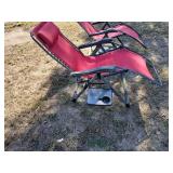 2 red zero gravity chairs with side table