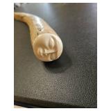 Piece of bone with carved face attached