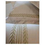 Three white with green trim decorative pillows