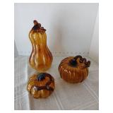 Three amber colored blown glass gourds. Largest 9 inches tall