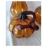 Three amber colored blown glass gourds. Largest 9 inches tall