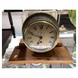 Circular clock on wood base stand. 9x12x4