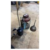 Two oil cans and an antique oil lamp