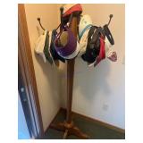 Wooden coat rack with assorted hats and visors