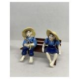 Porcelain country boy and girls sitting on bench