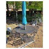 Wrought iron patio table and four chairs. Table is 48x 29 in tall. Barrel back chairs are 25x16 X 30 in tall. Includes umbrella.