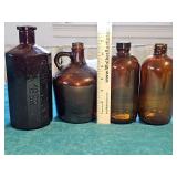 Three brown bottles and an amethyst replica bottle