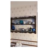 Wall shelf with netsky figures, spoon collection