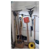 Lot of yard tools, brooms, shovels etc on wall