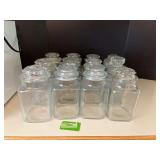 Twelve 9” glass canisters with various lids