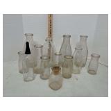 12 unmarked milk bottles and 1 glass baby bottle