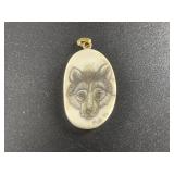 Scrimmed ivory pendant of a wolf, dated by Artist