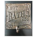 Cast iron wall hook that says "Hot BATHS 25ï¿½". It