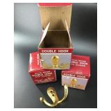 Set of three new in box brass double hooks. All id