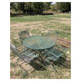 METAL PATIO TABLE AND FOUR CHAIRS. ONE CHAIR HAS